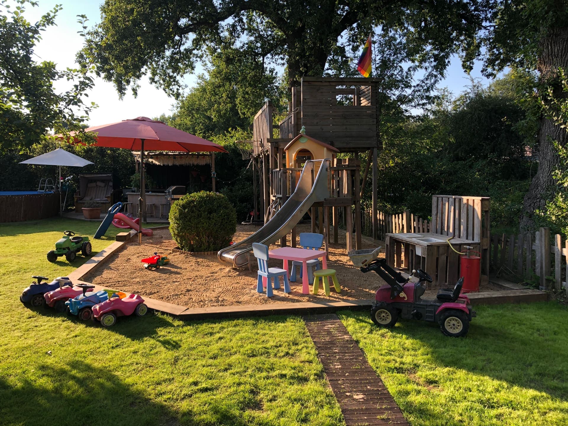 Spielplatz mit Rutsche, Klettergerüst und Sandkasten im Garten